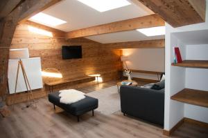 a living room with a couch and a tv at Résidence les 3 Sommets in Sarcenas