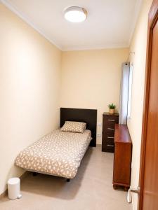 a bedroom with a bed and a dresser in it at Roca Playa Mogan in Puerto de Mogán