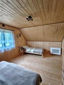 a room with a wooden ceiling with two beds in it at Relaks przy lesie in Idzbark