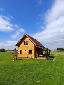 a large wooden house in a field of grass at Relaks przy lesie in Idzbark