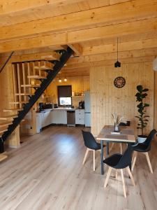 a kitchen and dining room with a table and chairs at Relaks przy lesie in Idzbark