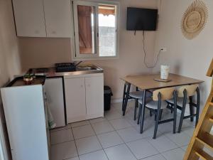 a small kitchen with a table and a sink at Résidence des Pikaniers in Anse-Bertrand +8 photos