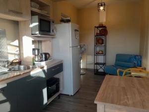 a kitchen with a white refrigerator and a table at Kazalou in Terre-de-Bas