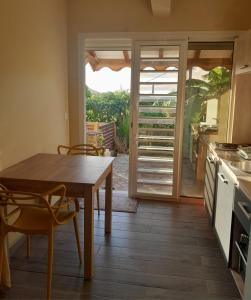 a kitchen with a table and chairs and a patio at Kazalou in Terre-de-Bas