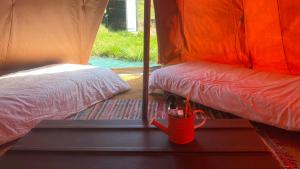a red bucket is on a bed in a tent at Igloo, Lodge et Tipi confortable in L Honor De Cos