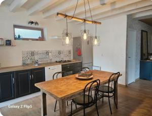 a kitchen with a wooden table and chairs at Chez yoan et laurie in Corbelin