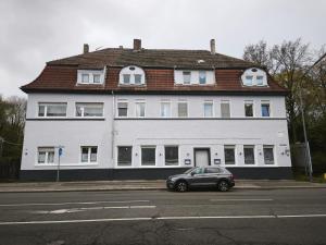 a car parked in front of a large white building at My Apartments&Rooms 04 in Gelsenkirchen