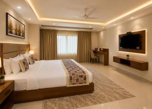 a bedroom with a large bed and a television at Hotel Grand Suites Premier - Near Delhi Aerocity in New Delhi +29 photos