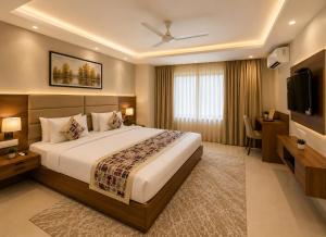 a bedroom with a large bed and a television at Hotel Grand Suites Premier - Near Delhi Aerocity in New Delhi