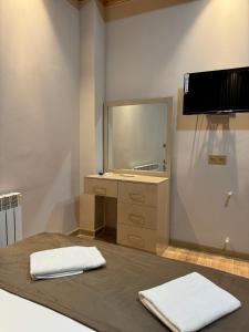 a bathroom with a mirror and a bed with two towels at Gold Hotel Quba in Quba