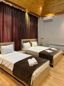 two beds in a hotel room with two bedsvisor at Gold Hotel Quba in Quba