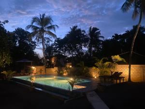 a swimming pool with lights in a backyard at night at See Turtle Villa in Tangalle
