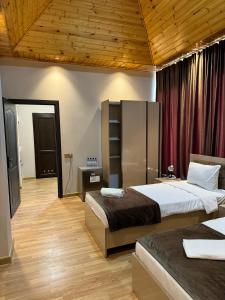 a bedroom with two beds and a wooden ceiling at Gold Hotel Quba in Quba +87 photos