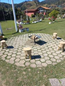 a group of benches and a fire pit in a park at Pousada Maia em Flor chale azul in Resende