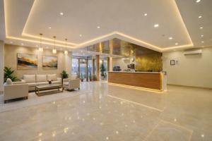 a large living room with a couch and a kitchen at Hotel Grand Suites Premier - Near Delhi Aerocity in New Delhi