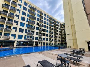 a large building with a swimming pool in front of it at Cozy Studio at SCSP Suites in Kota Kinabalu
