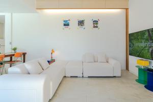 a living room with a white couch and a tv at 제주살랑 in Tŏksu-dong +81 photos