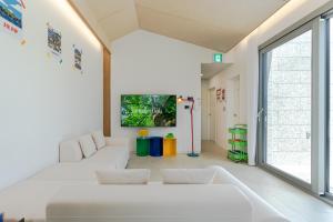 a living room with a white couch and a large window at 제주살랑 in Tŏksu-dong