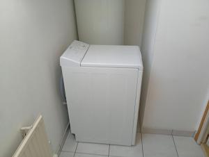 a white washer and dryer in a small room at La maison aux papillons in Tregueux