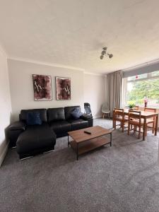 a living room with a black couch and a table at Macintosh lower in Bellshill