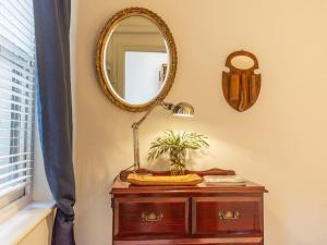 a mirror on a wall next to a table with a lamp at Secluded Hackney Cottage Near Botanic Gardens with Free Parking - Koala Stay in Adelaide