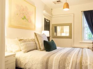 a bedroom with a bed with pillows on it at Secluded Hackney Cottage Near Botanic Gardens with Free Parking - Koala Stay in Adelaide