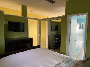 a bedroom with a bed and a flat screen tv at Charming 1BR Villa Steps from Red Hook Hotspots in Nazareth