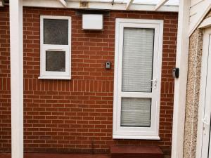 a brick house with two windows and a door at Harman Suites 1 & 2 in Leeds +10 photos