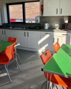 a kitchen with green and orange chairs and tables at Scalloway Caravan Park in Scalloway +15 photos