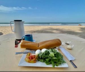 a plate of food on a table at the beach at J'adore House in Abémé