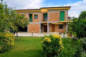 a brick house with a yard with flowers at Smart Suite at Villa Anna - Bike Friendly in Buonconvento