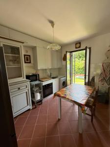 a kitchen with a table in the middle of it at Casolare De Ranieri - appartamento in villa bifamiliare a 500m dal mare in Marina di Massa
