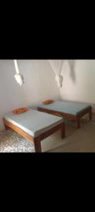 two beds sitting next to each other in a room at J'adore House in Abémé