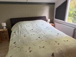 a bed with a blanket with birds on it at Suzie's Cottage in Aalten