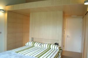 Schlafzimmer mit einem Bett mit gestreiftem Kopfteil in der Unterkunft PR Albeitaría in Reis