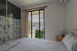 a bedroom with a bed and a large window at Blue Lemon Hideaway in Poros