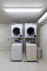 two washing machines sitting next to each other in a room at Hotel Kiyoshi Nagoya in Nagoya
