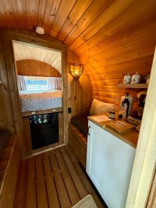 a small kitchen in a log cabin with a window at Barrel de Verreblik in Pieterburen