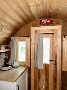 a kitchen with wooden walls and a window and a counter at Barrel de Verreblik in Pieterburen +7 photos