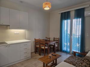 a kitchen and living room with a table and a kitchen and a dining room at Diogenes Apartments in Samos