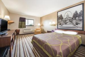 a hotel room with a bed and a flat screen tv at Super 8 by Wyndham Nevada in Nevada