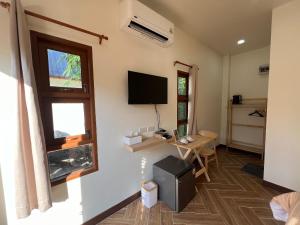 a room with a television and a desk and a window at ธนาภา 