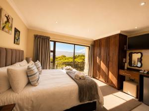 a bedroom with a large bed with a large window at On Appointment at the Sea in Wilderness
