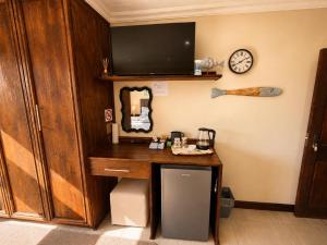 a room with a wooden desk with a clock on the wall at On Appointment at the Sea in Wilderness