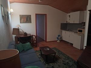 a living room with a blue couch and a table at AQC - A Quinta Chama in Caldas da Rainha