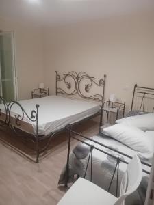 two beds in a room with white walls at La Vecchia Lanterna in Montecorvino Rovella