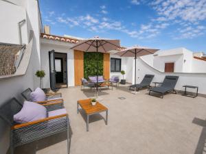 a patio with chairs and tables and umbrellas at Apartamentos Sibarys in Nerja