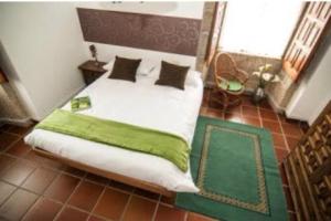 a bedroom with a large bed with a green blanket at Casa rural La rectoral in Areas