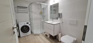 a white bathroom with a shower and a washing machine at Hotel Rebstock in Baden-Baden