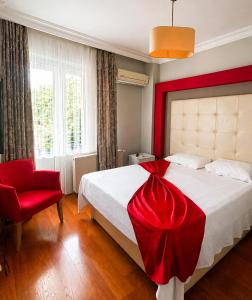 a bedroom with a bed with a red dress on it at Green Moringa Termal Hotel in Termal +44 photos